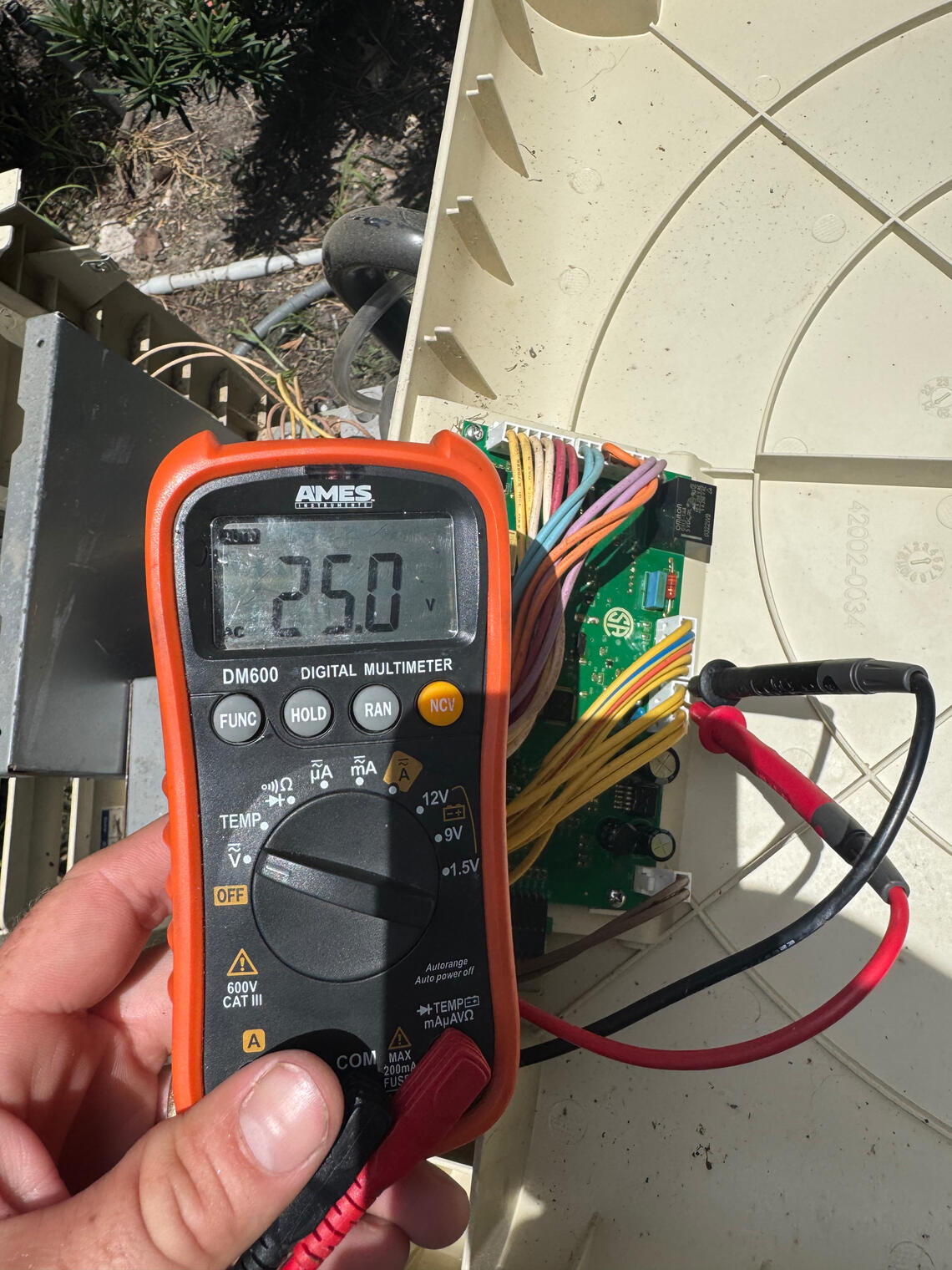 Pool Heater Diagnostic Testing Katy TX Pool heater control board being diagnosed with a multimeter during professional equipment troubleshooting by Drew Pools in Katy, Texas.